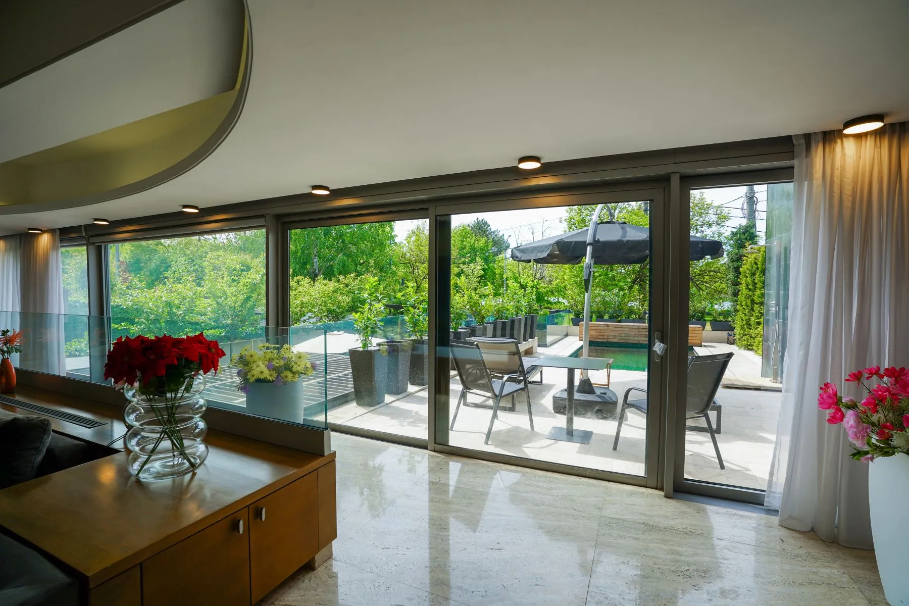 Floor-to-ceiling living-room doors opening toward the private pool terrace