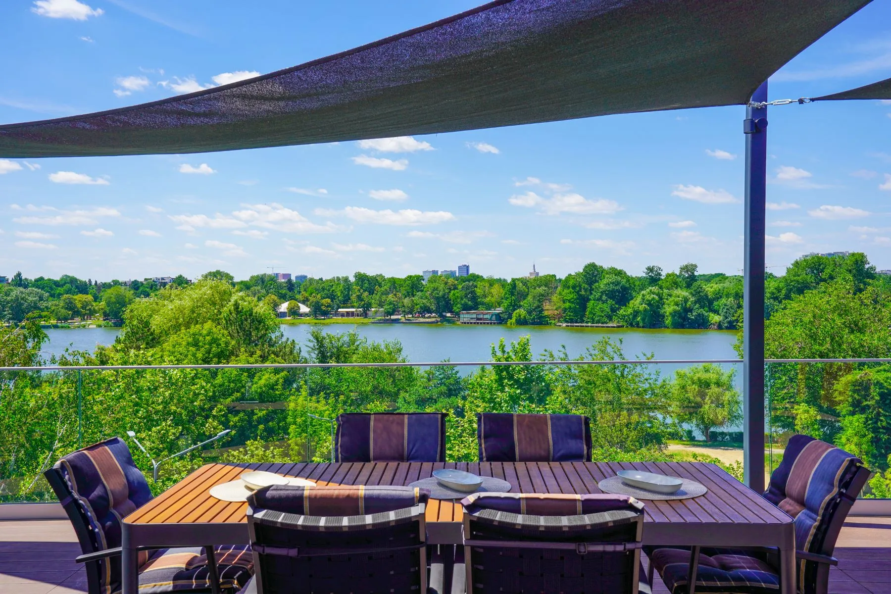 Lake-view rooftop dining area surrounded by mature green scenery