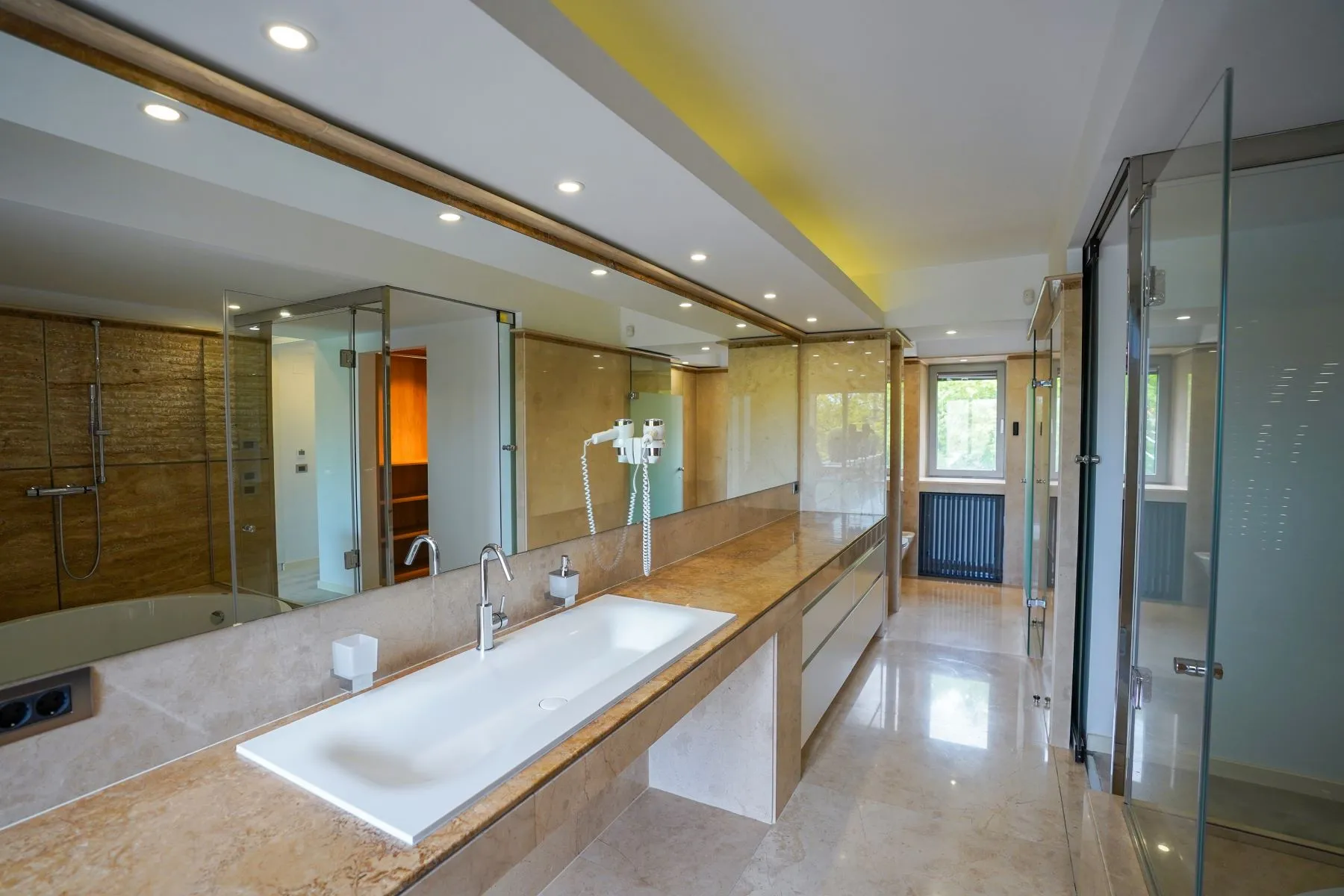 Luxury en-suite bathroom with long double vanity and glass shower enclosure