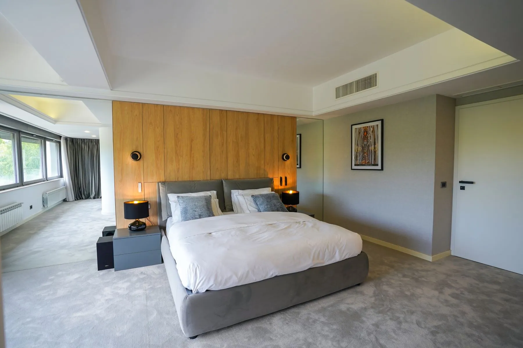 Principal bedroom with upholstered bed and serene lake-facing outlook