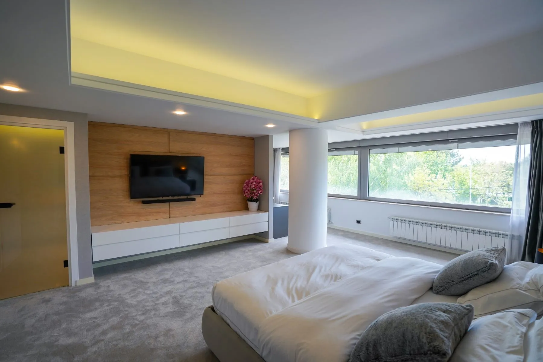 Large master suite with television wall and panoramic waterfront windows