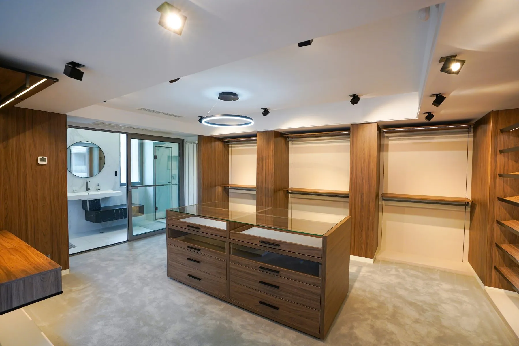 Bespoke timber dressing room with central storage island and illuminated rails