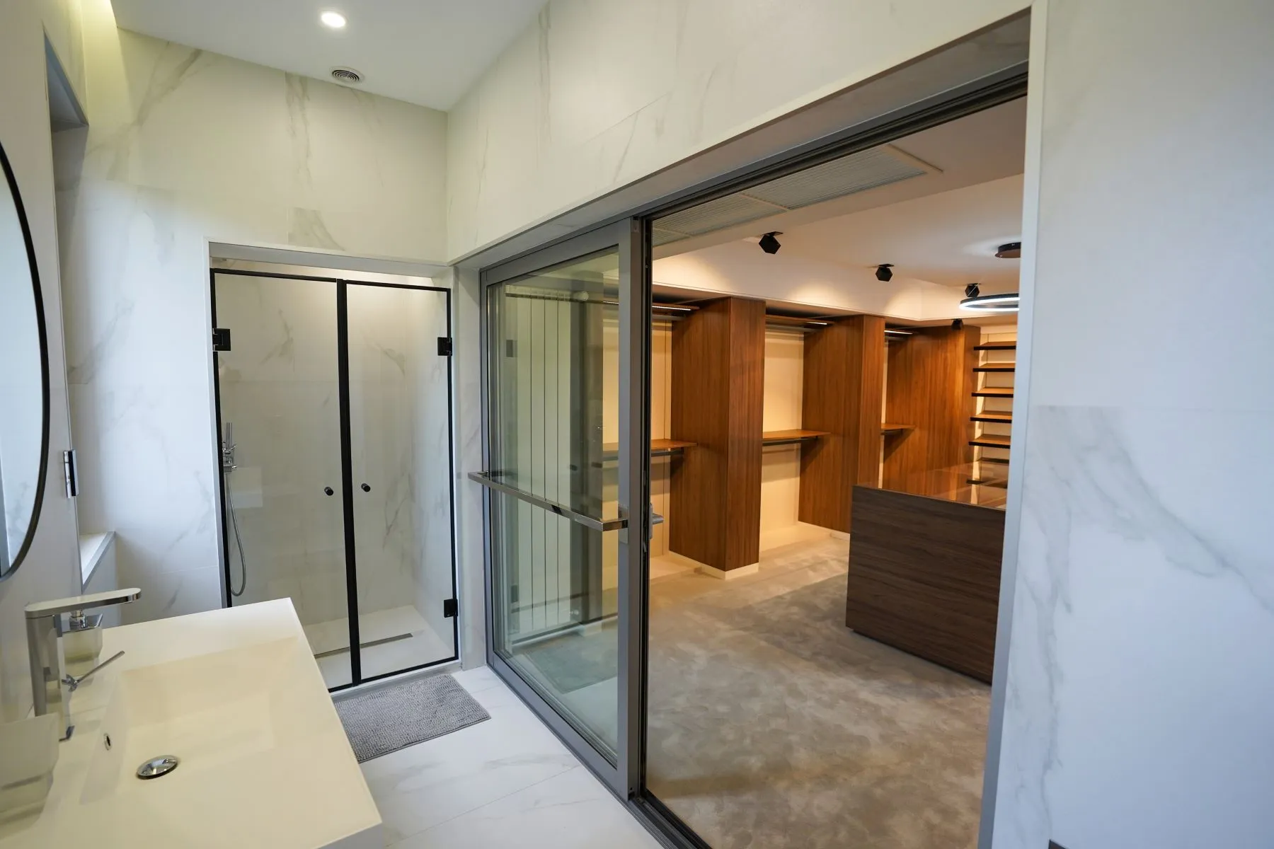 Glass-enclosed shower room opening directly into the master dressing area