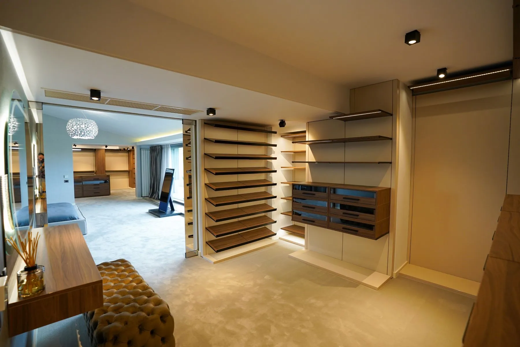 Spacious bespoke dressing room with full-height shelving and timber cabinetry