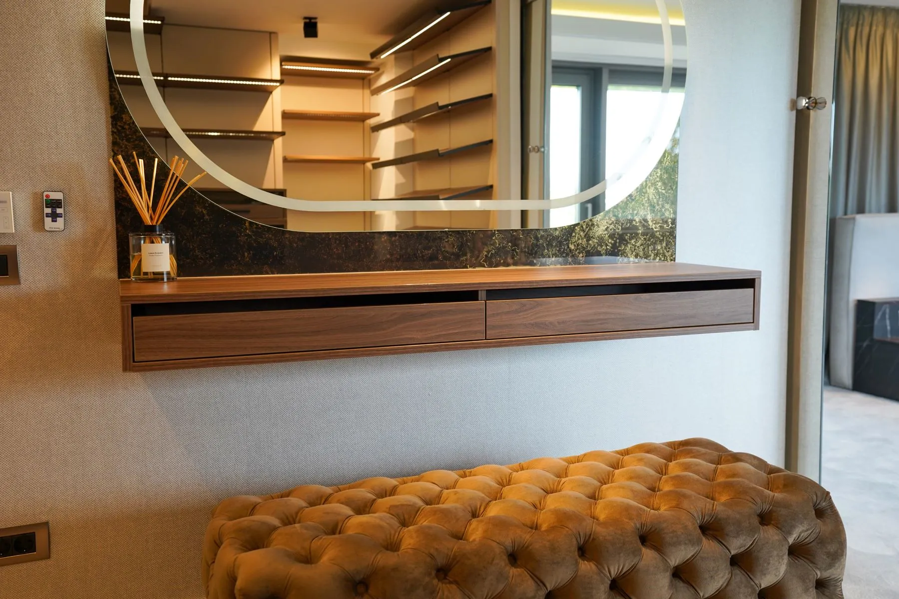 Dedicated dressing-room vanity with oval mirror and upholstered bench