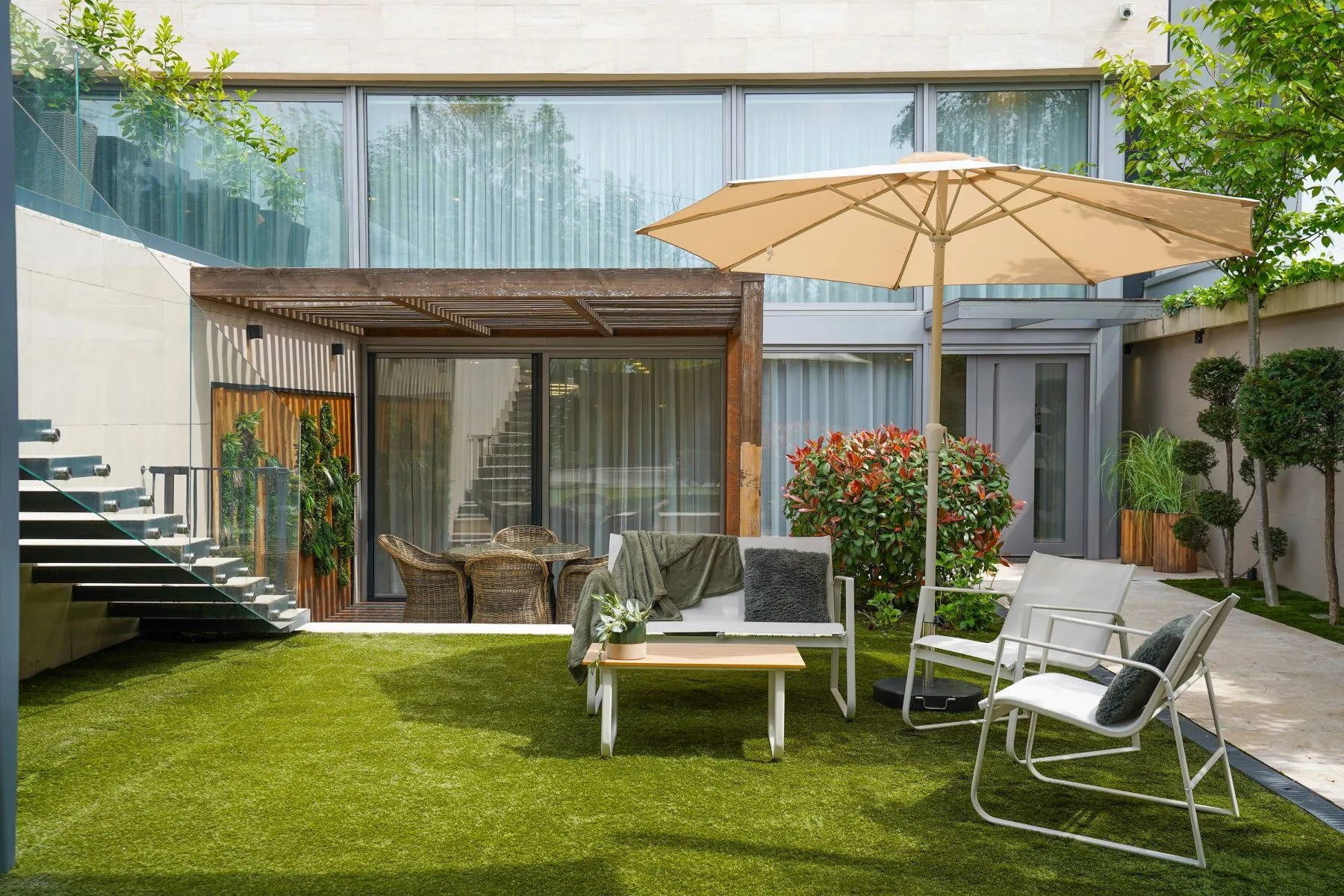 Sheltered garden terrace with lounge furniture and manicured planting