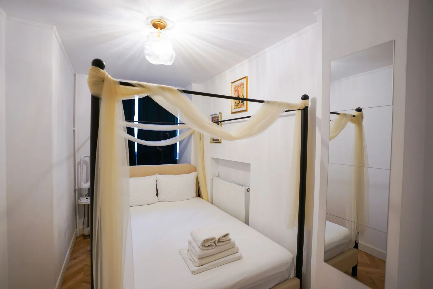 Flexible third sleeping room with canopy bed and fresh white finishes