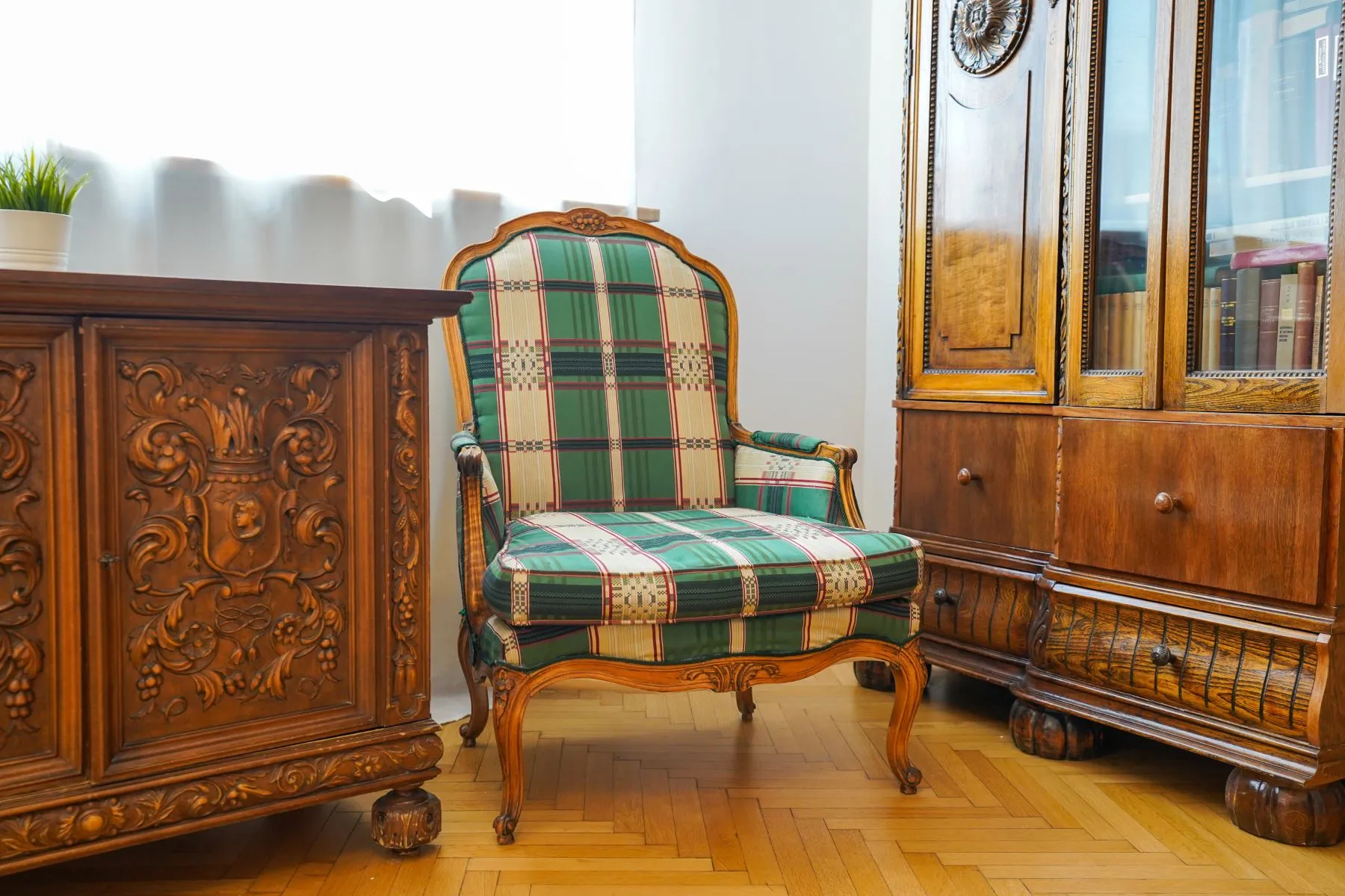 Carved antique cabinet and upholstered armchair in the historic reception room