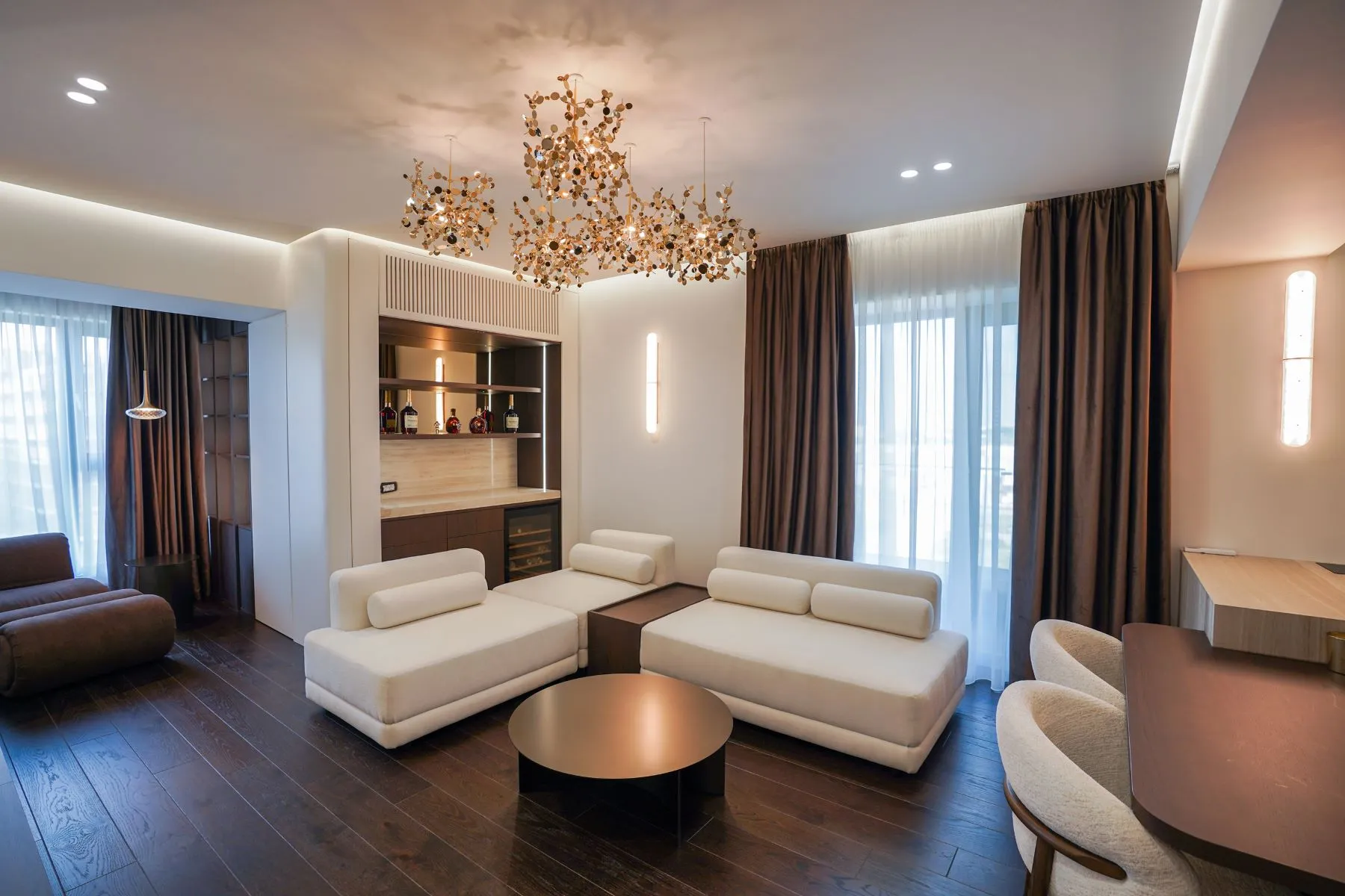 Designer Pipera living room with cream seating, chandelier and illuminated cabinetry
