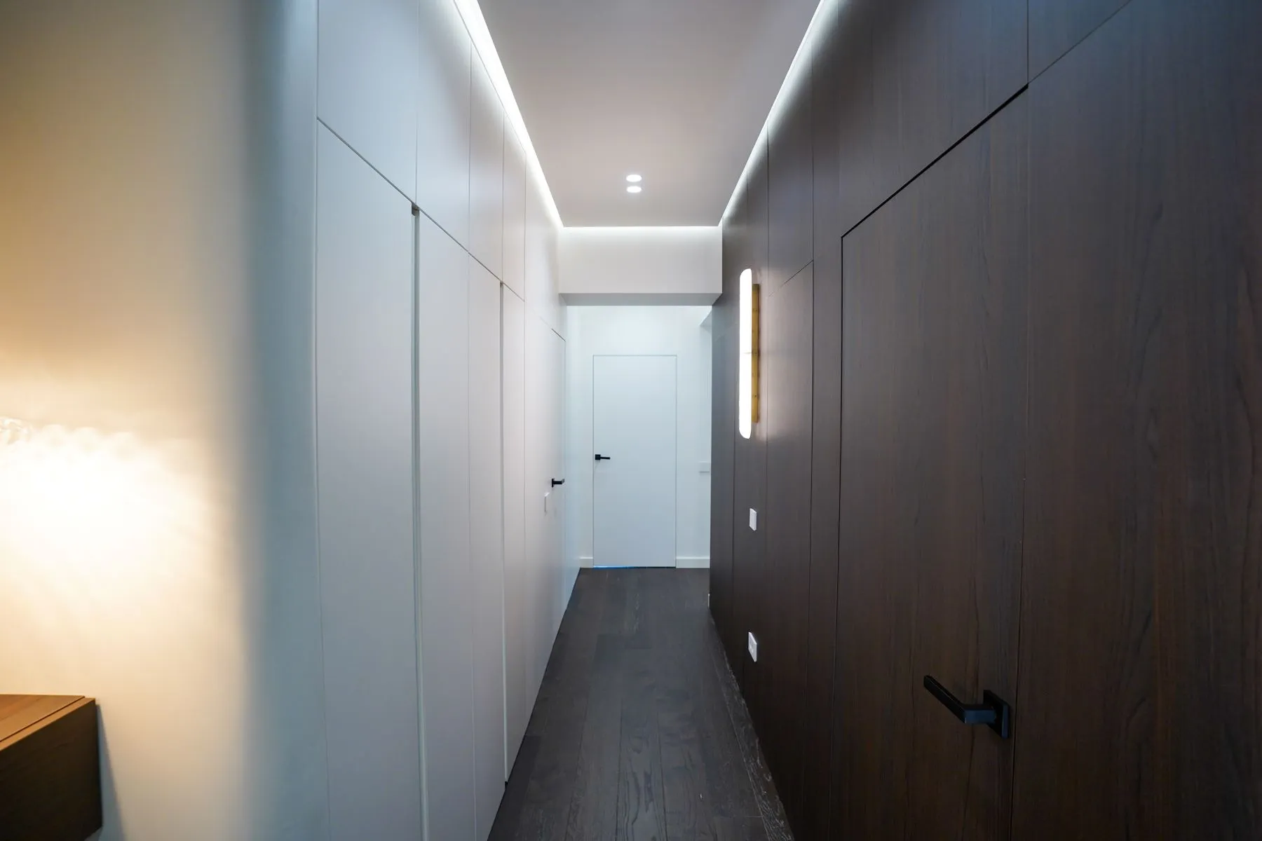 Long private hallway with integrated wardrobes and recessed ceiling lighting