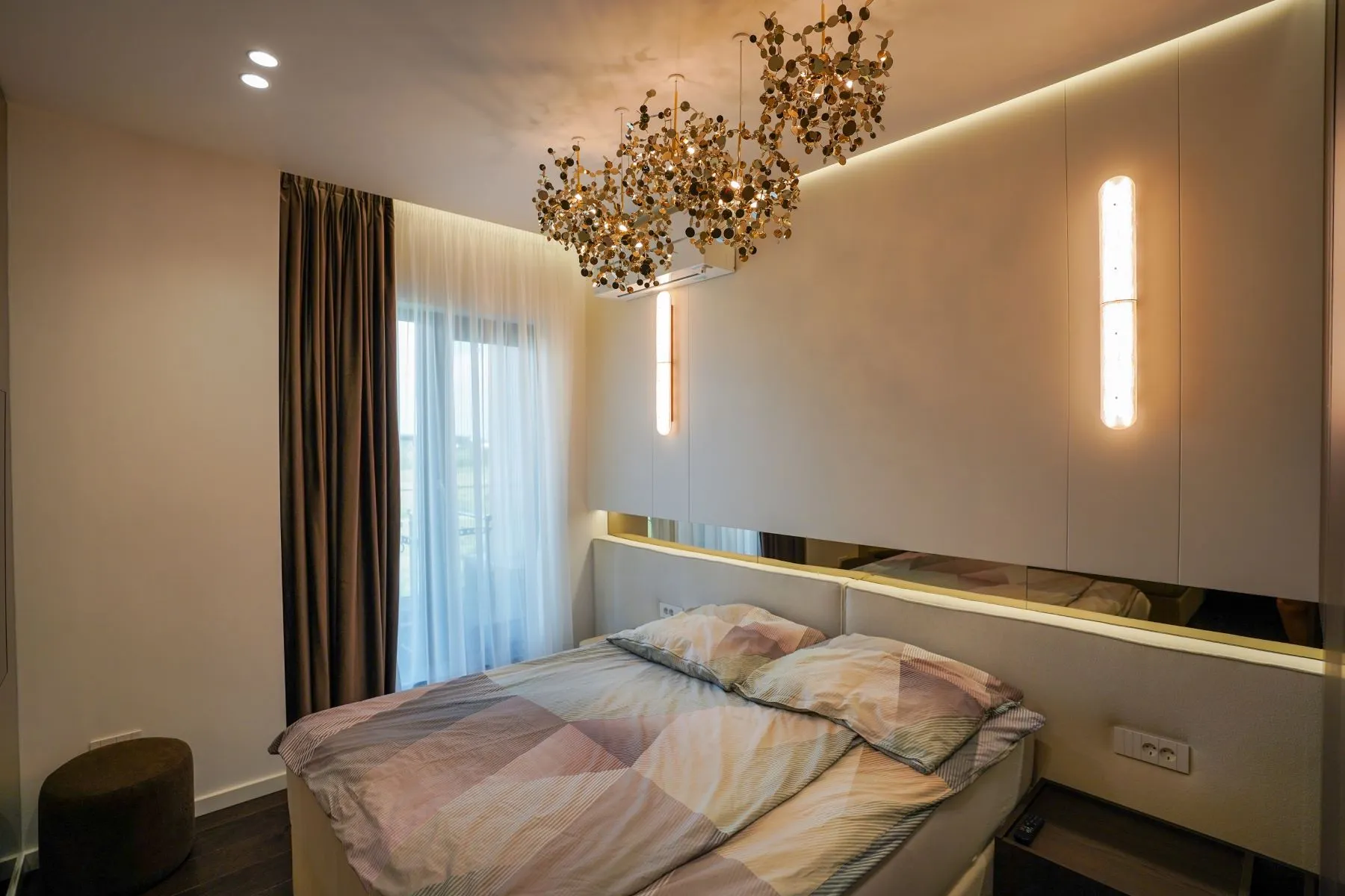 Principal double bedroom with upholstered wall, timber cabinetry and terrace doors
