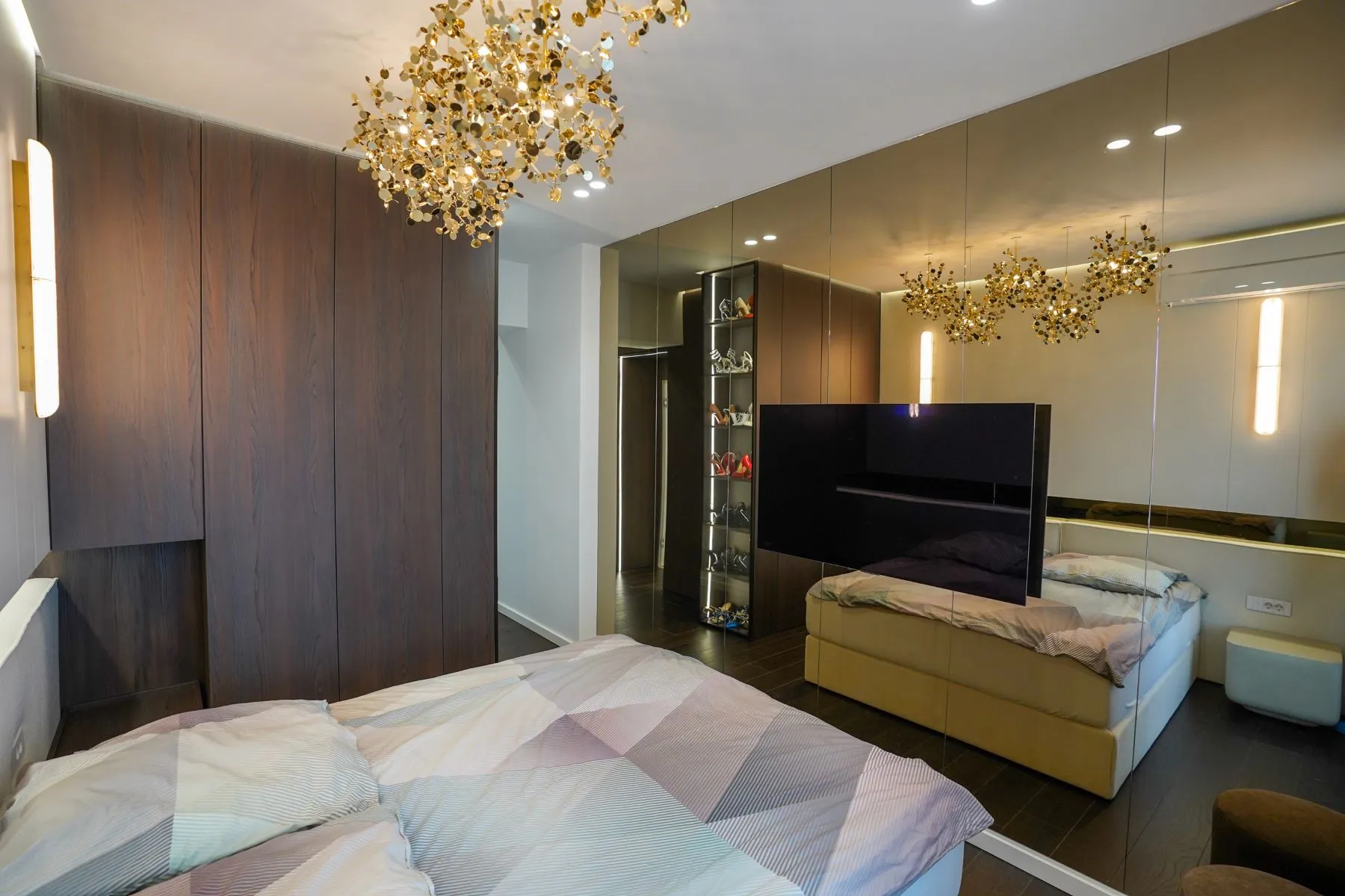 Principal bedroom with mirrored wardrobes, television and bespoke storage