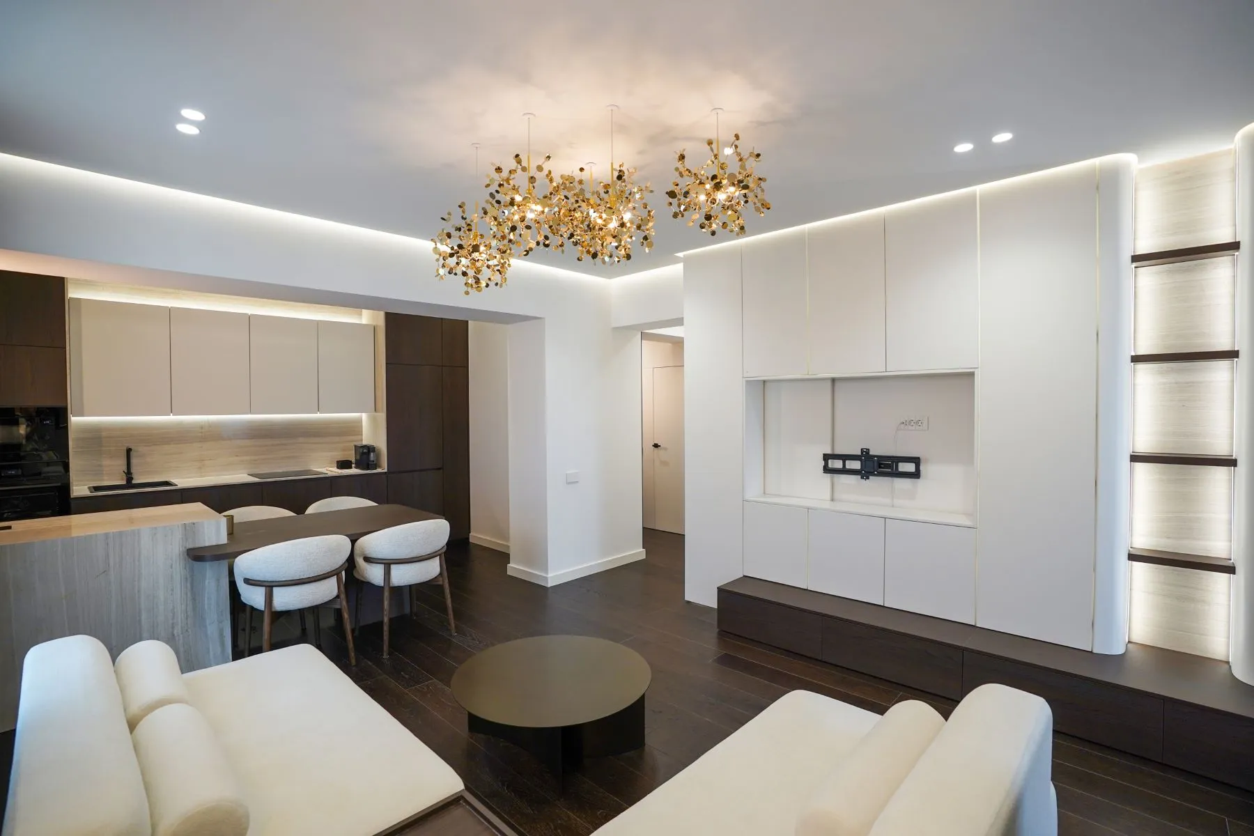 Open-plan luxury lounge and kitchen with breakfast bar and custom storage