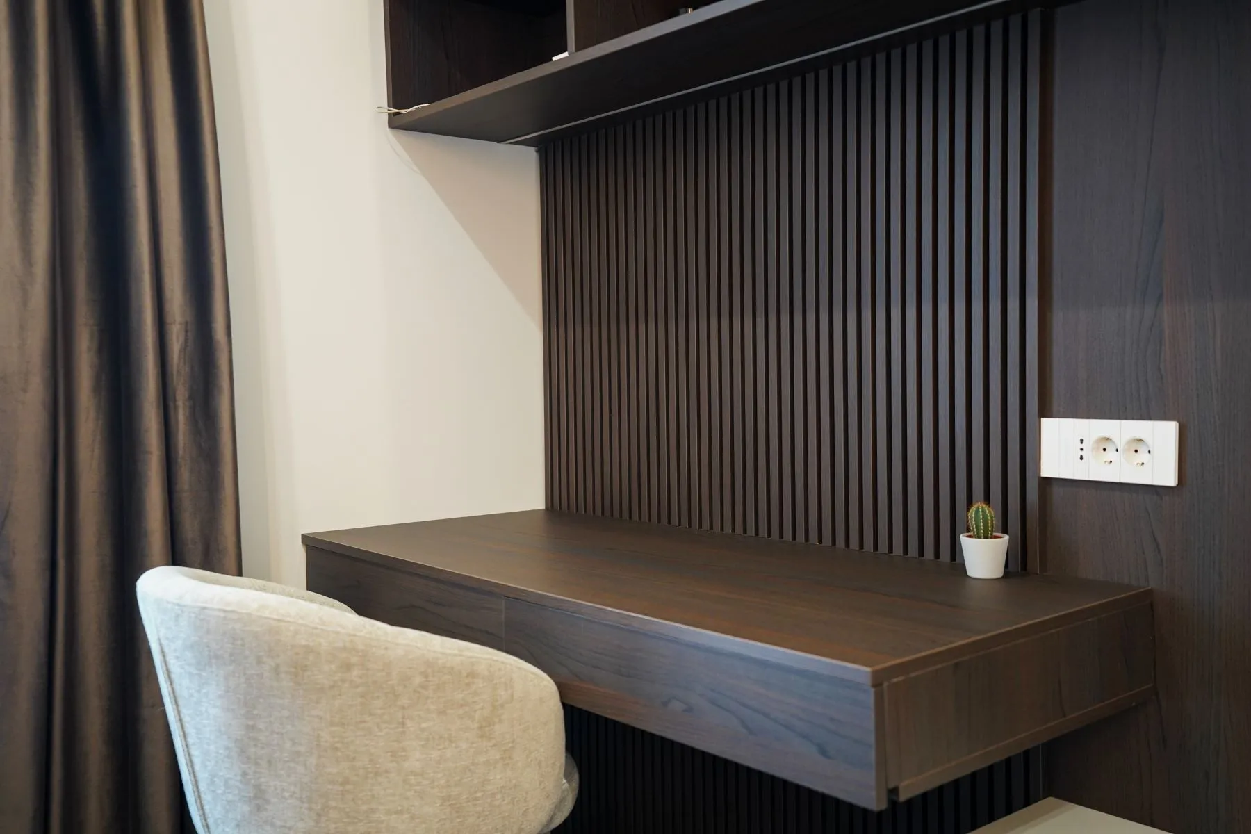 Custom floating workspace with timber slat wall and upholstered chair