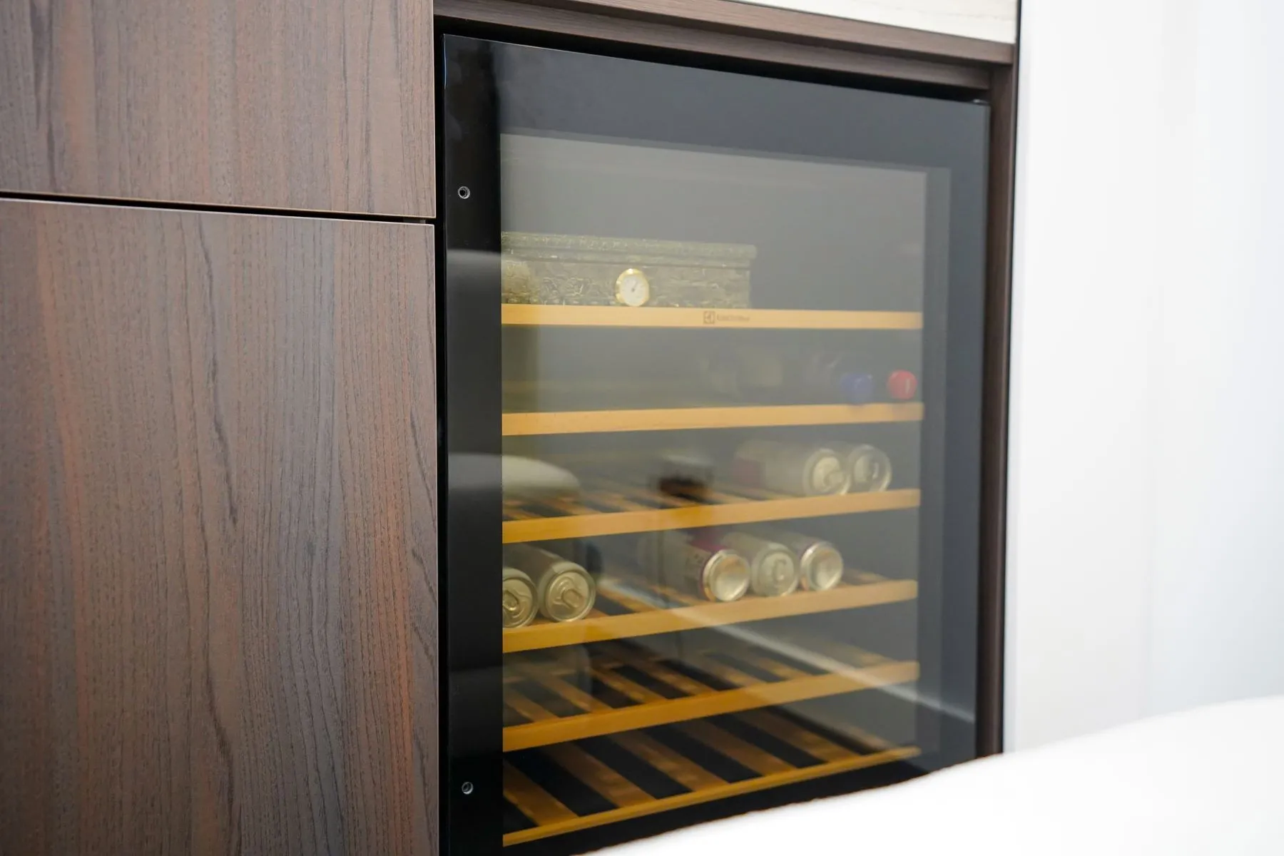 Integrated wine cabinet with illuminated shelves beside the living area