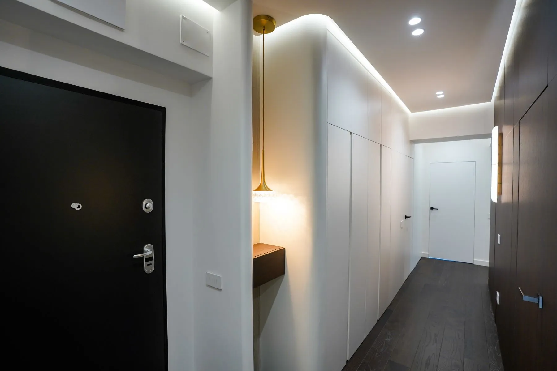 Contemporary entrance hall with full-height fitted cupboards and pendant light