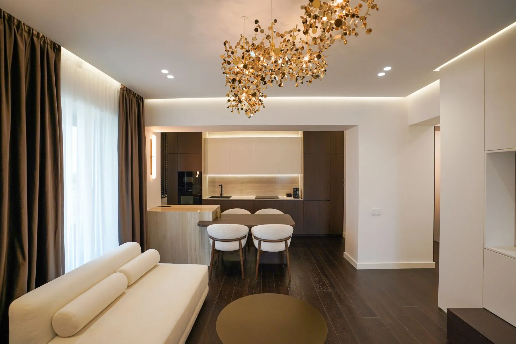 Open-plan lounge viewed toward the fitted kitchen and illuminated hallway
