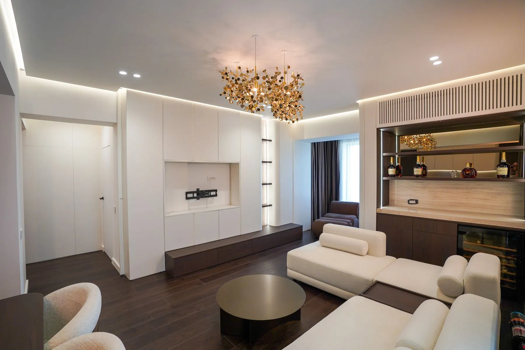 Luxury living space with bespoke bar shelving, television wall and ambient lighting