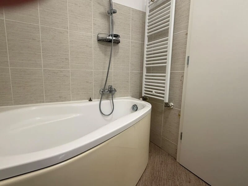 Corner bathtub with shower and heated towel rail in the main bathroom
