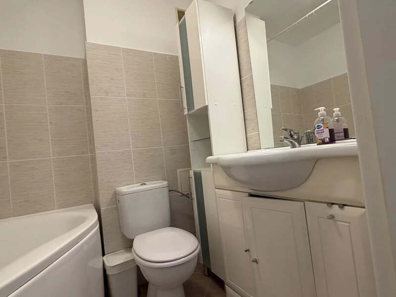 Bathroom vanity storage and mirror beside the corner bathtub