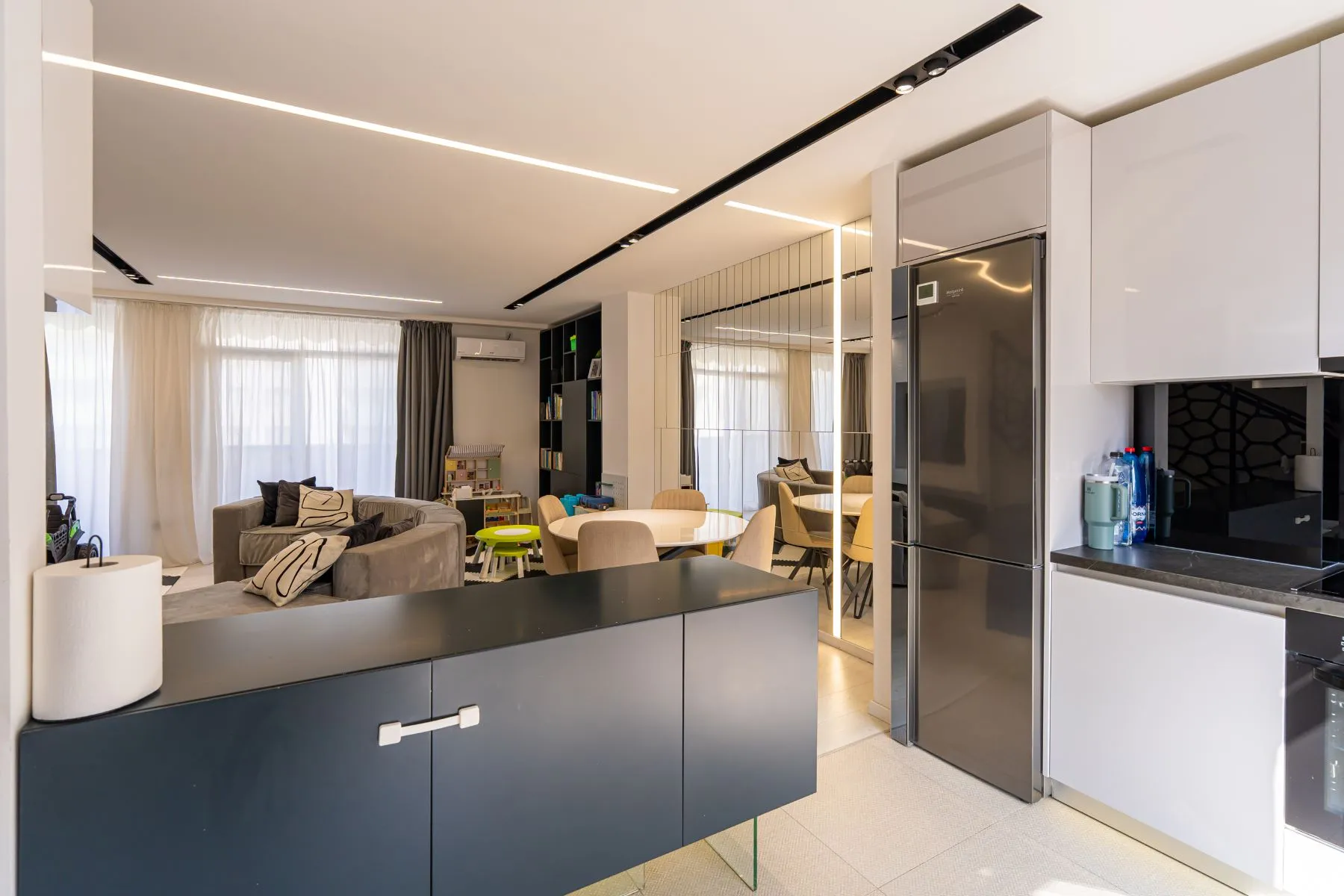Two-tone kitchen island and full-height cabinetry beside the living room