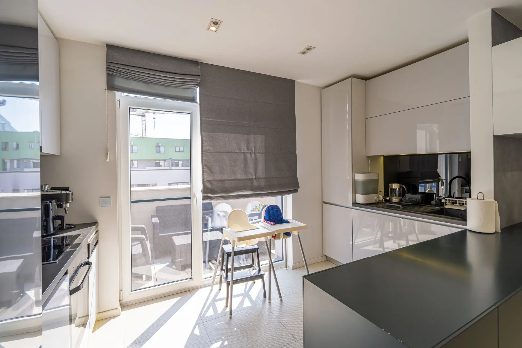 Bright fitted kitchen with breakfast table and doors to the private terrace
