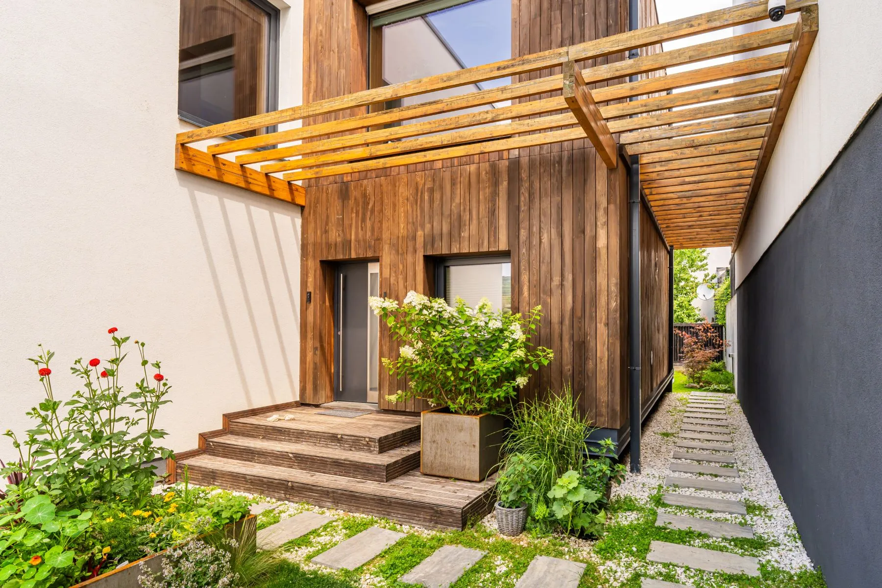 Landscaped villa entrance beneath a timber pergola in Cluj-Napoca