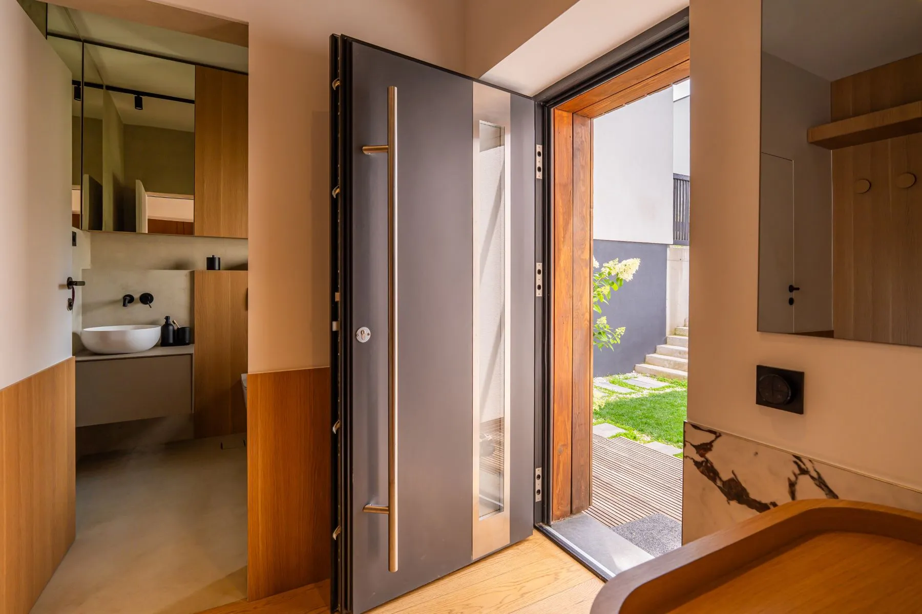 Timber-framed front entrance beside a modern ground-floor guest bathroom