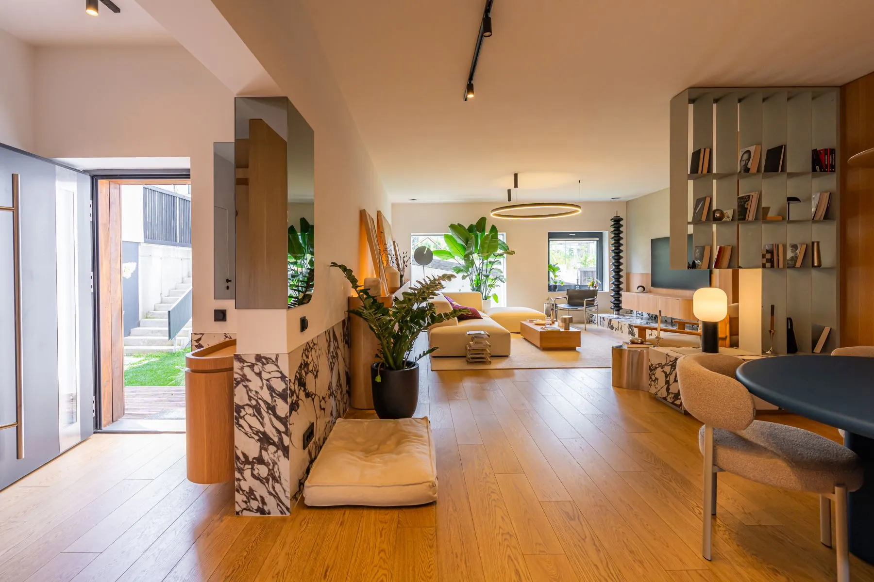 Open-plan villa interior connecting the entrance, dining area and living room