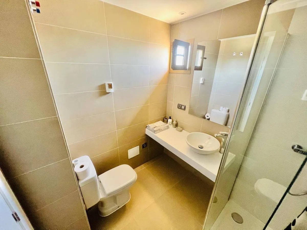 Second bathroom with glass-enclosed shower and modern vanity