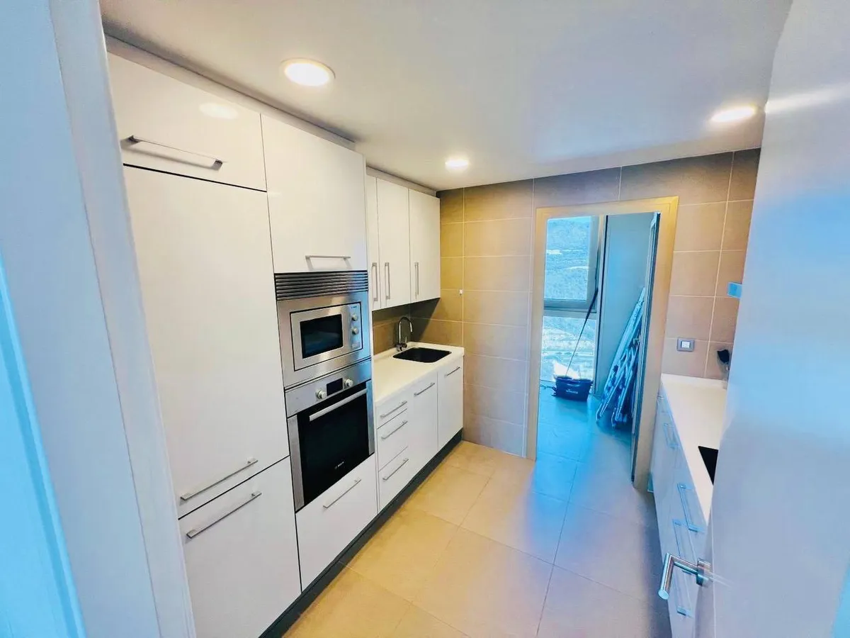 Galley kitchen with integrated oven, microwave and full-height cabinetry