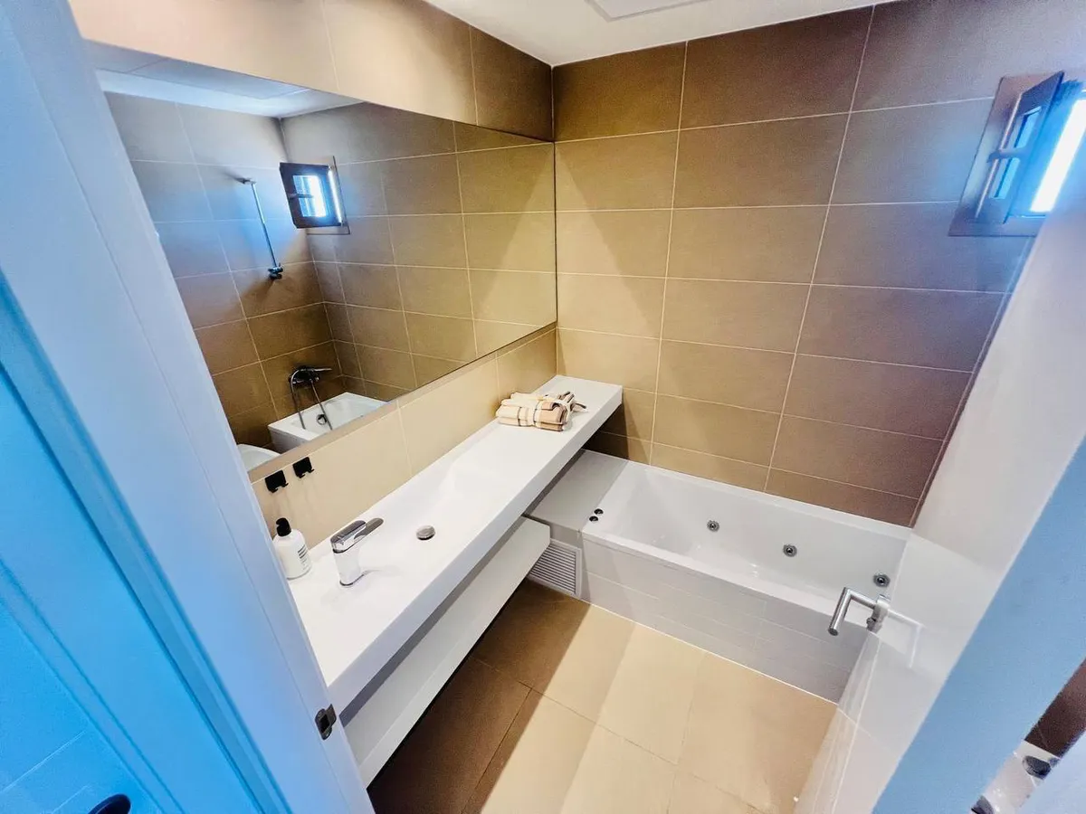 Contemporary bathroom with Jacuzzi bathtub and wide white vanity