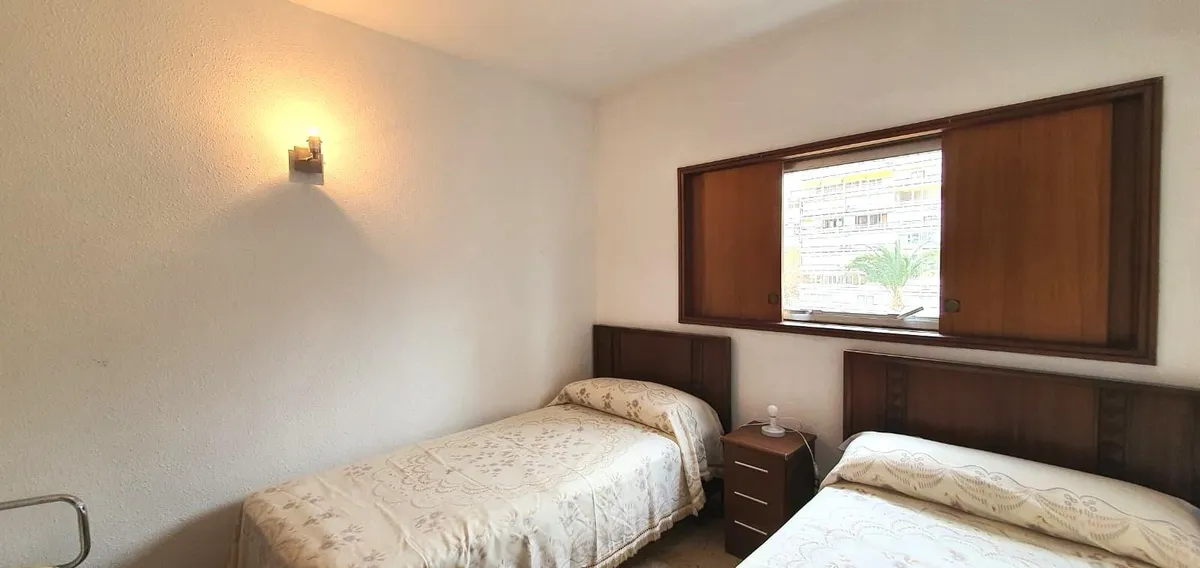 Twin bedroom with two single beds and timber headboard storage