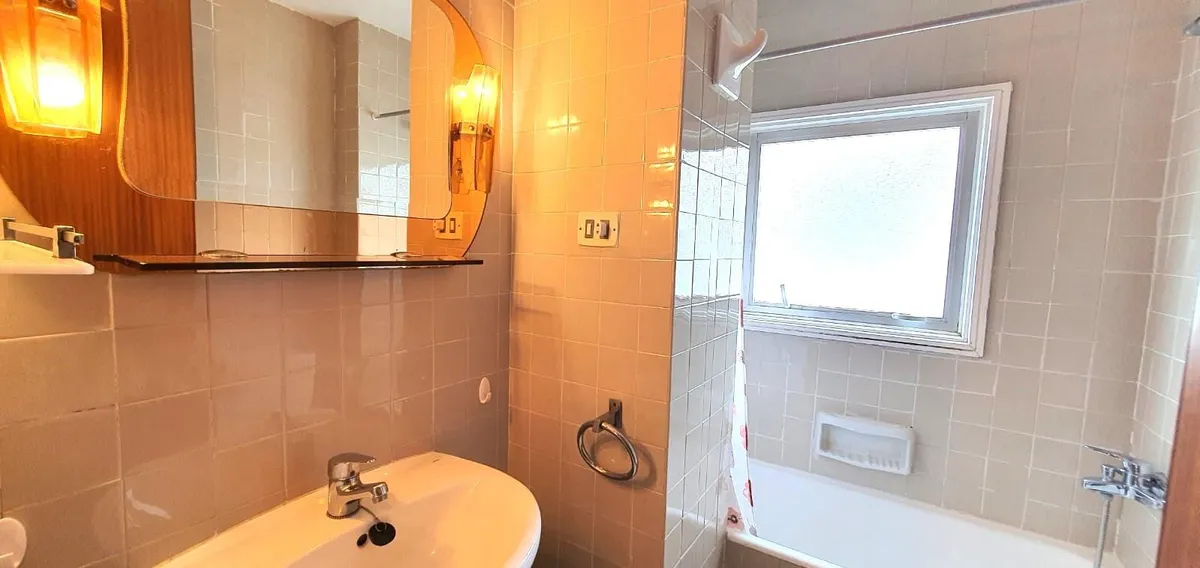 Second bathroom with bathtub, vanity and exterior window