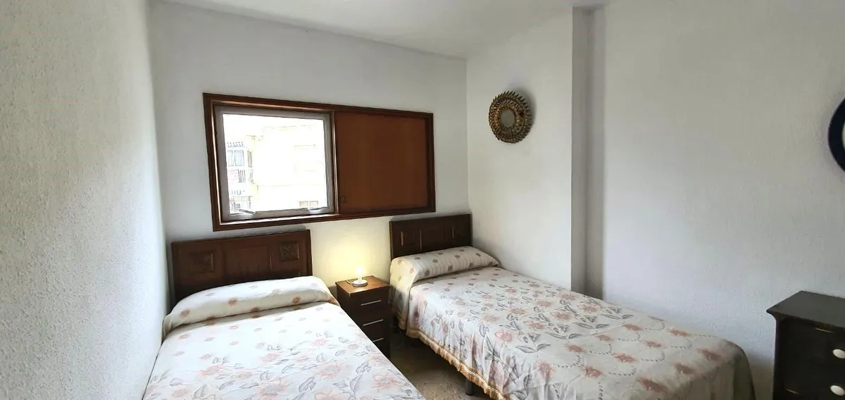 Twin bedroom with dresser and two bedside lamps