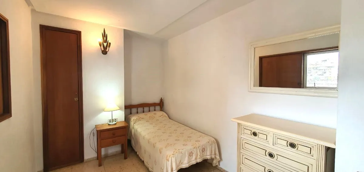 Quiet single bedroom with dresser and built-in timber storage