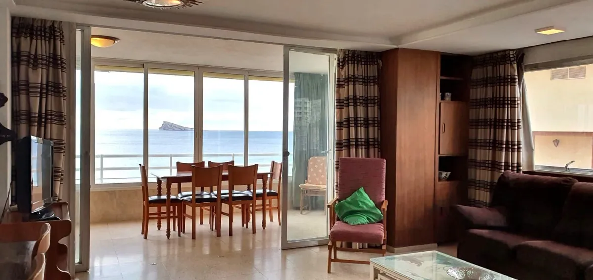 Open living and dining room framed by the sea-view balcony