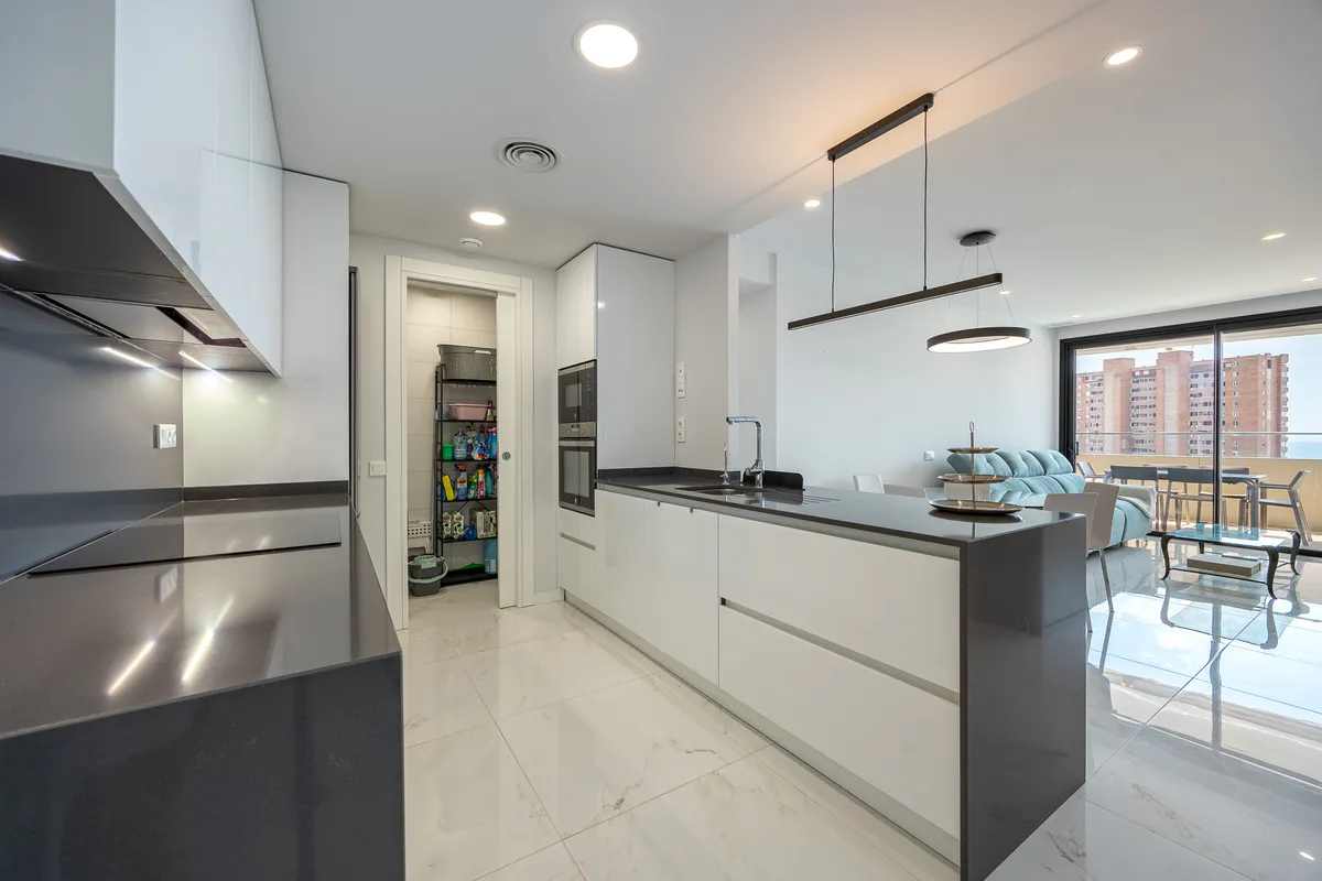 Open kitchen island with stools beside the apartment entrance