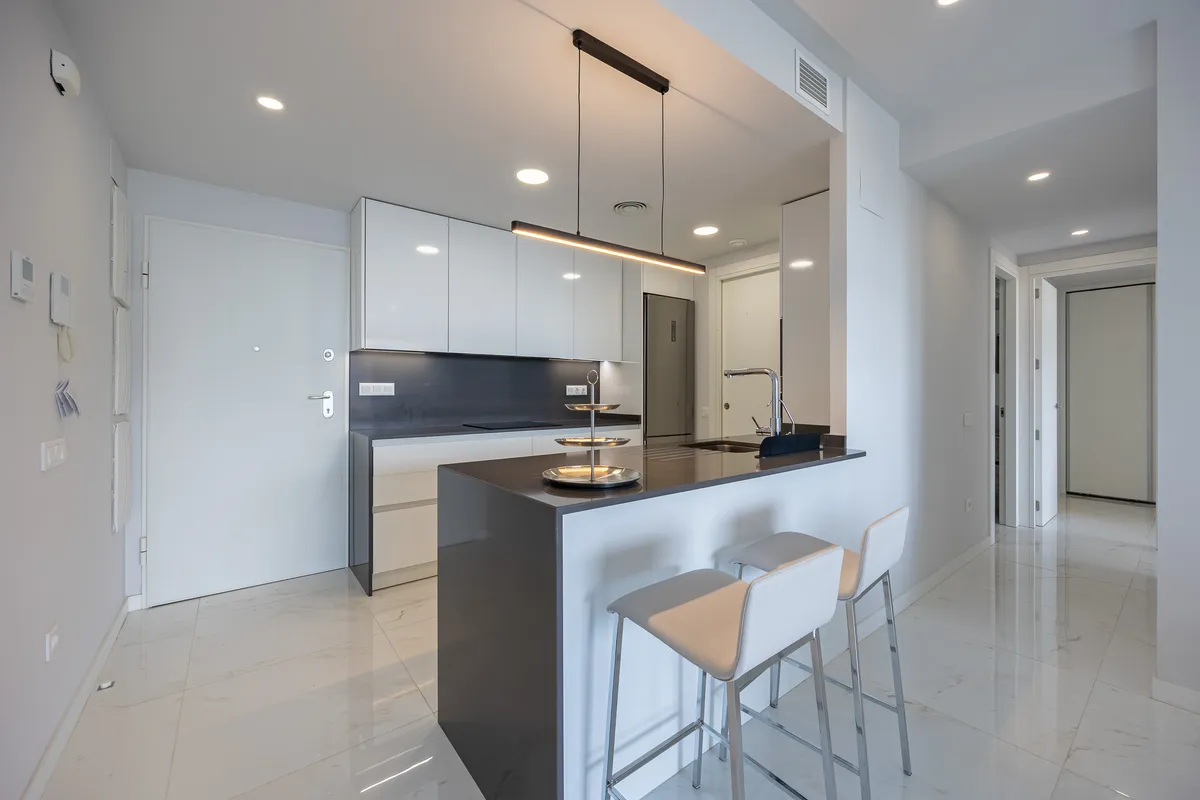 Modern white kitchen with breakfast peninsula and integrated appliances