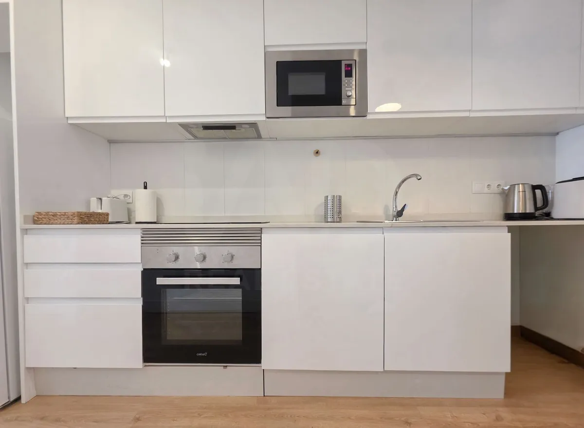 Kitchen cooking area with oven, hob, microwave and sink
