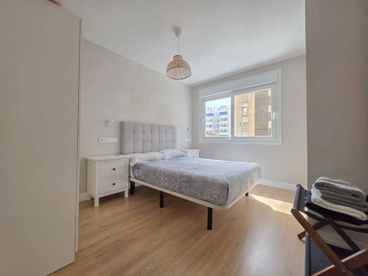 Bright principal double bedroom with upholstered headboard