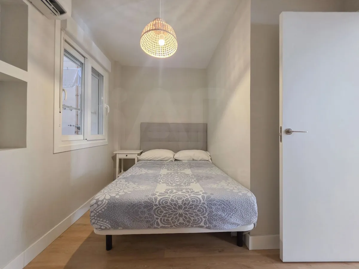 Second bedroom with double bed and compact bedside table