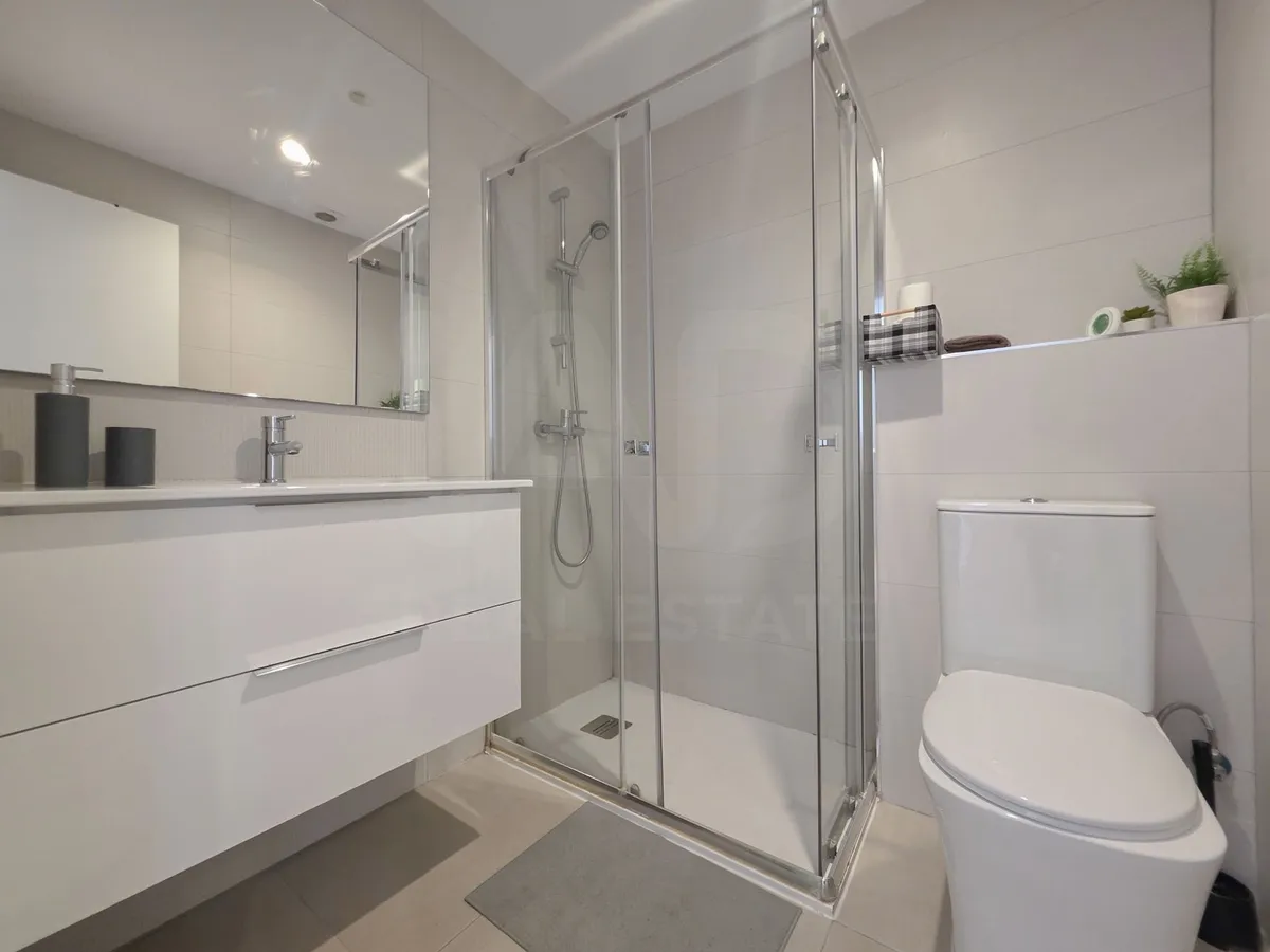 Second bathroom with glass-enclosed shower and wide vanity