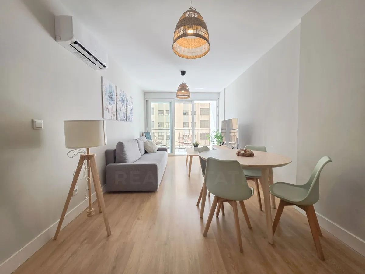 Bright open-plan lounge with dining table and air conditioning