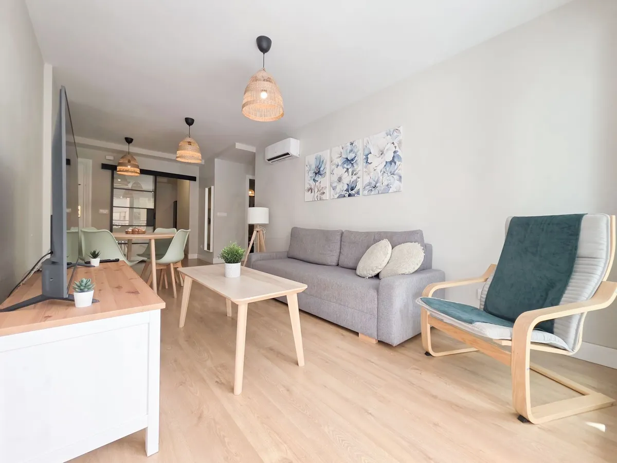 Comfortable sofa seating and dining area beneath woven pendant lights
