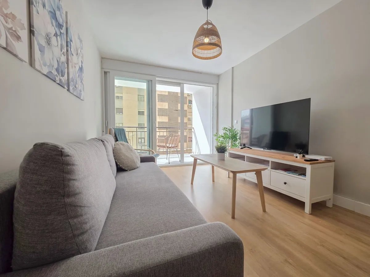 Grey sofa and television area facing the terrace doors