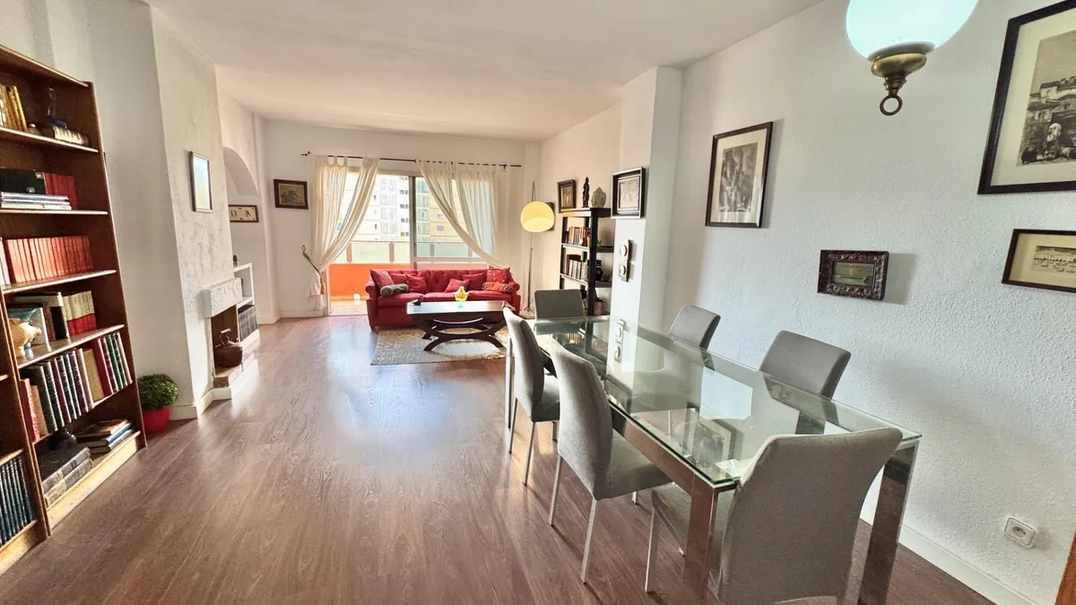 Spacious Málaga living and dining room with library storage and balcony light