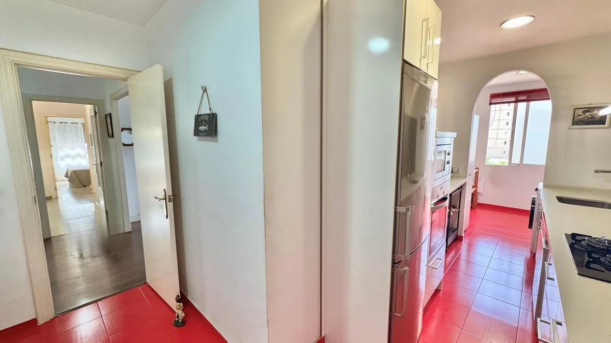 Fitted kitchen corridor leading toward the adjoining laundry room