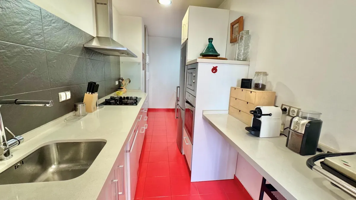 Long kitchen worktop with gas hob, oven and stainless-steel sink