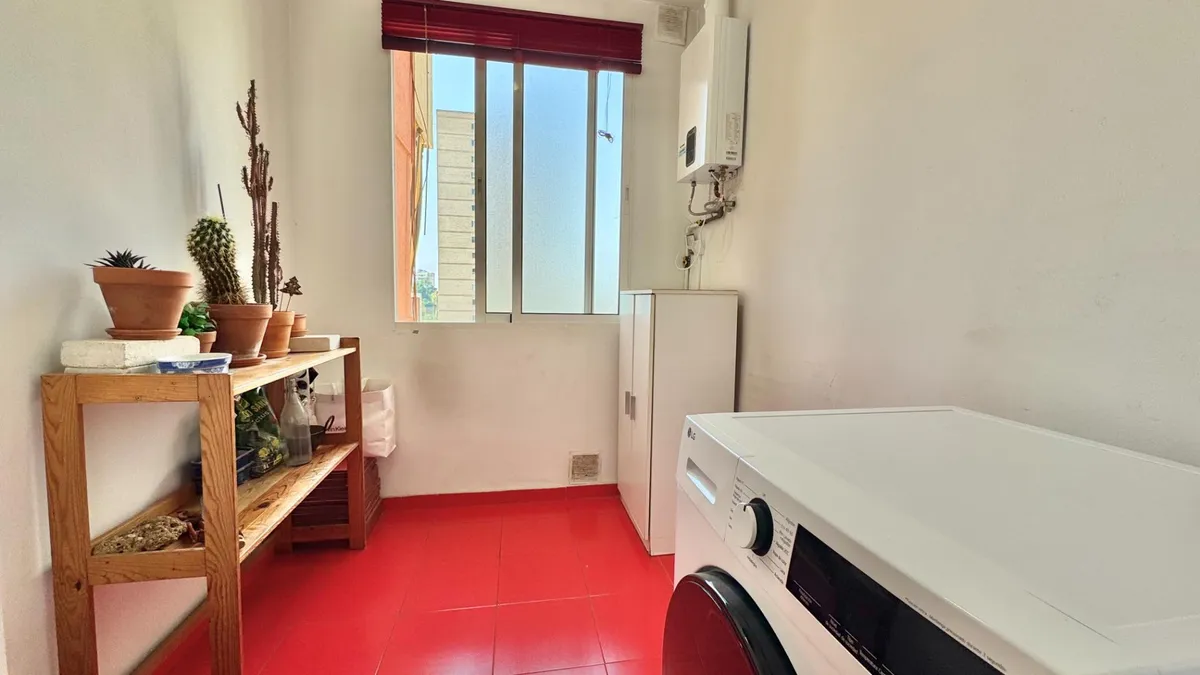Separate laundry room with washing machine and utility storage